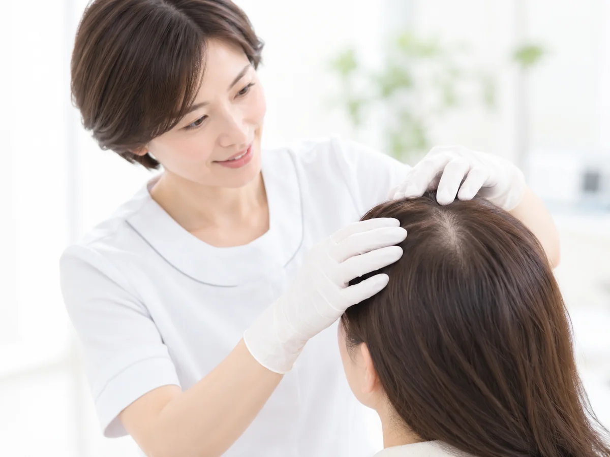 女性スタッフが頭皮と毛髪の状態を確認する様子