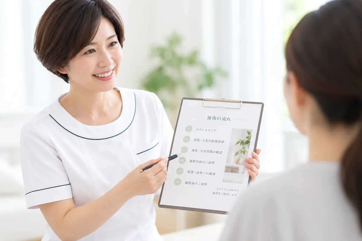 女性スタッフが施術内容を説明する様子