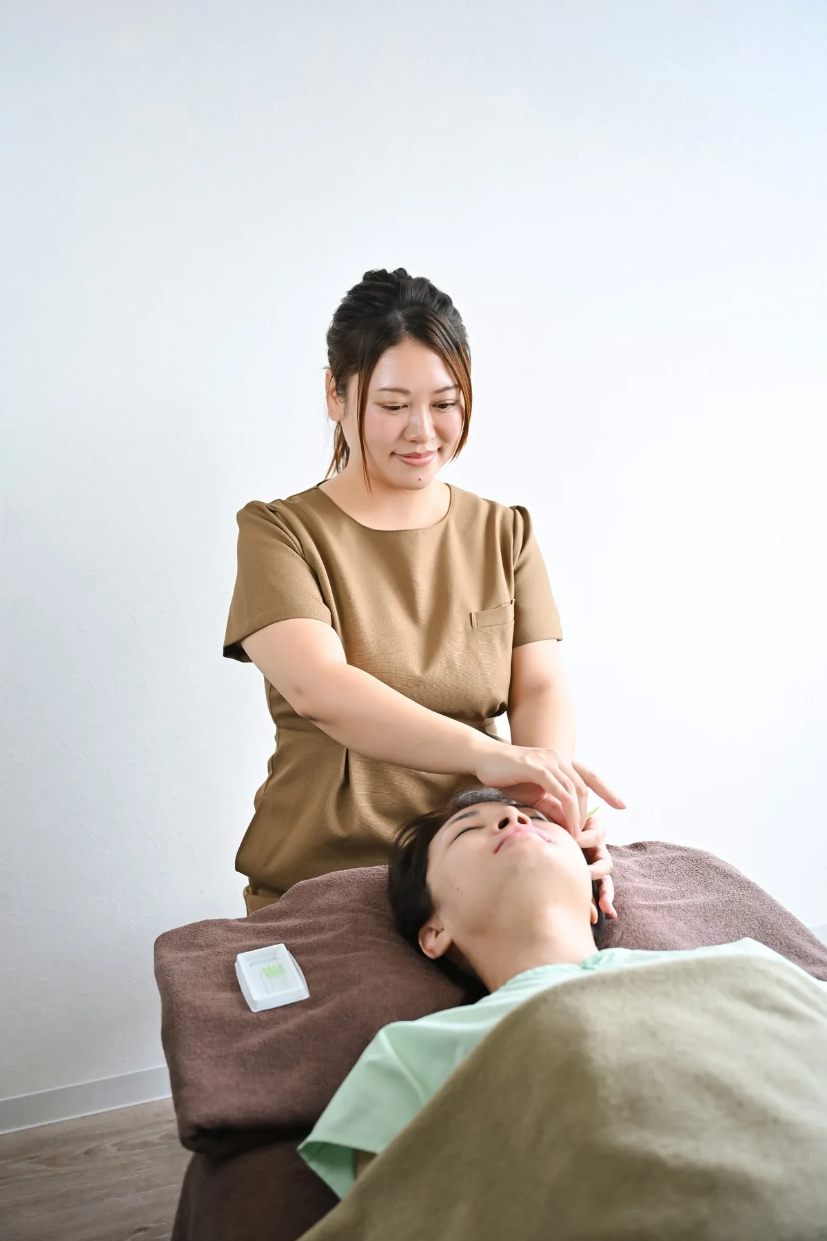 女性スタッフが鍼灸施術を行う様子